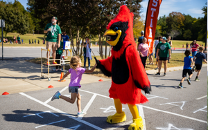 Cardinal Mascot giving a student a high five